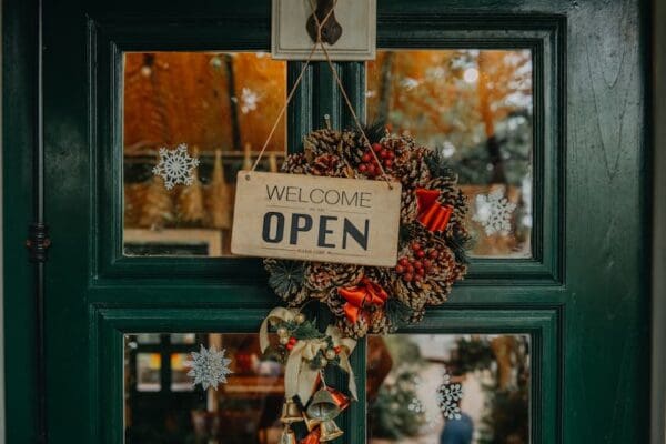 dark wooden door with welcome sign and wreath